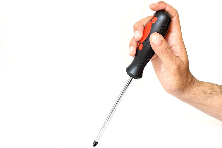 close-up photo of person holding black and gray screwdriver, background