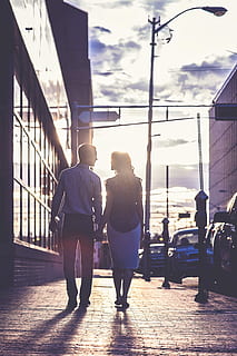 woman wearing black shirt standing near man wearing grey sports shirt holding hands at sunrise HD wallpaper