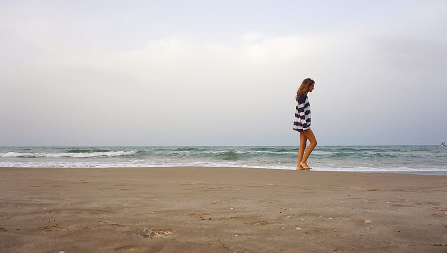 person in black and white striped mini dress walking near seashore HD wallpaper