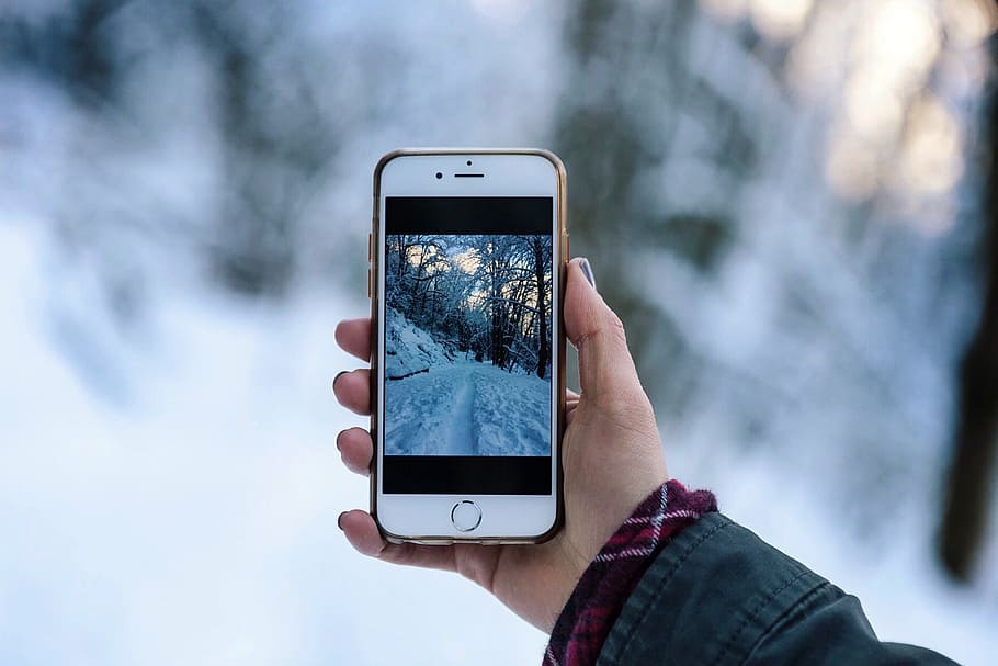 person holding silver iPhone 6, person holding turned on iPhone taking photo road covered with snow HD wallpaper