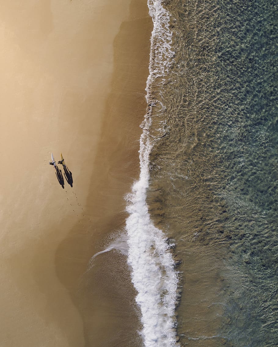 aerial photography of two persons walking along seashore during daytime, sea waves through shore, HD wallpaper