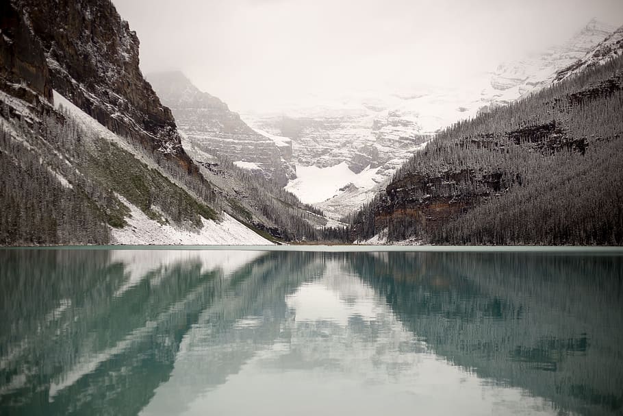 body of water near mountain covered by snow at daytime, clear body of water surrounded by mountains HD wallpaper