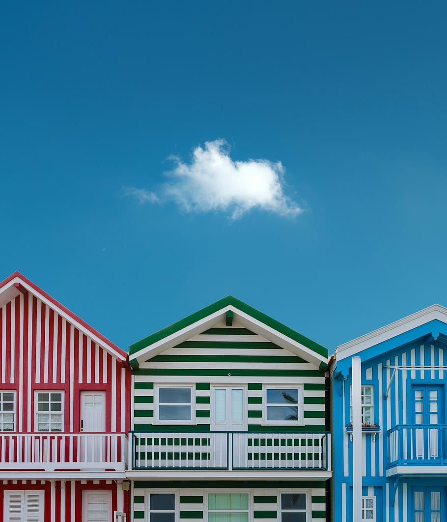 three assorted-color houses next to each other, three assorted-color painted houses under blue and white cloudy sky HD wallpaper