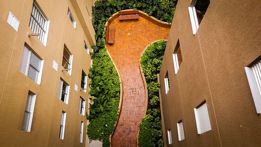 tiled pathway between buildings, aerial view photography of two brown wooden park benches HD wallpaper
