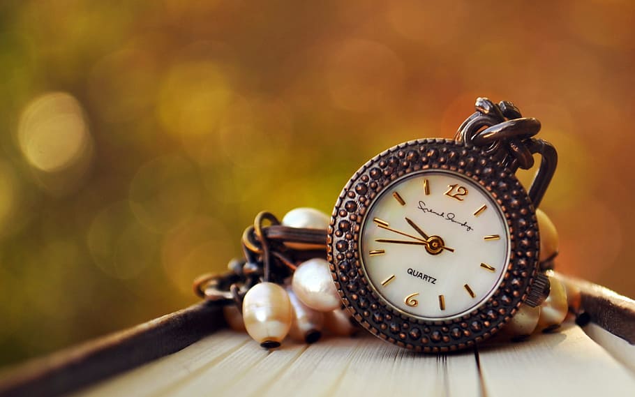 selective focus photo of round gold-colored Quartz analog watch on brown surface HD wallpaper