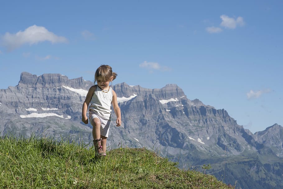 girl standing on grasses within mountain range, alp, canton of glarus, HD wallpaper