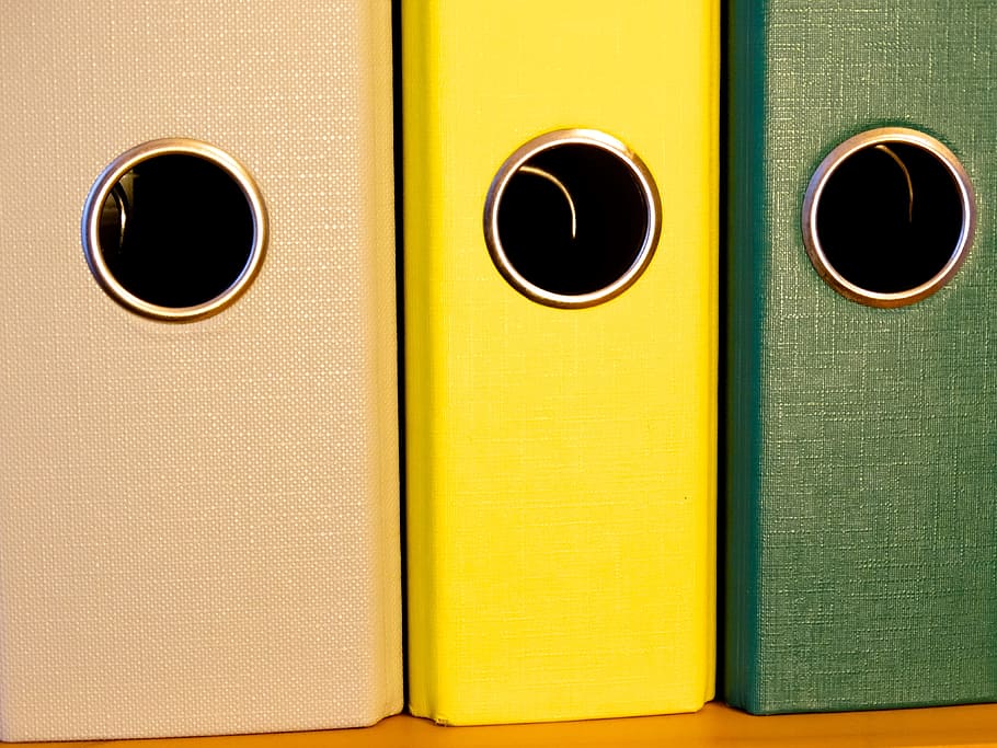 brown, yellow, and green binders on brown wooden surface, hole HD wallpaper