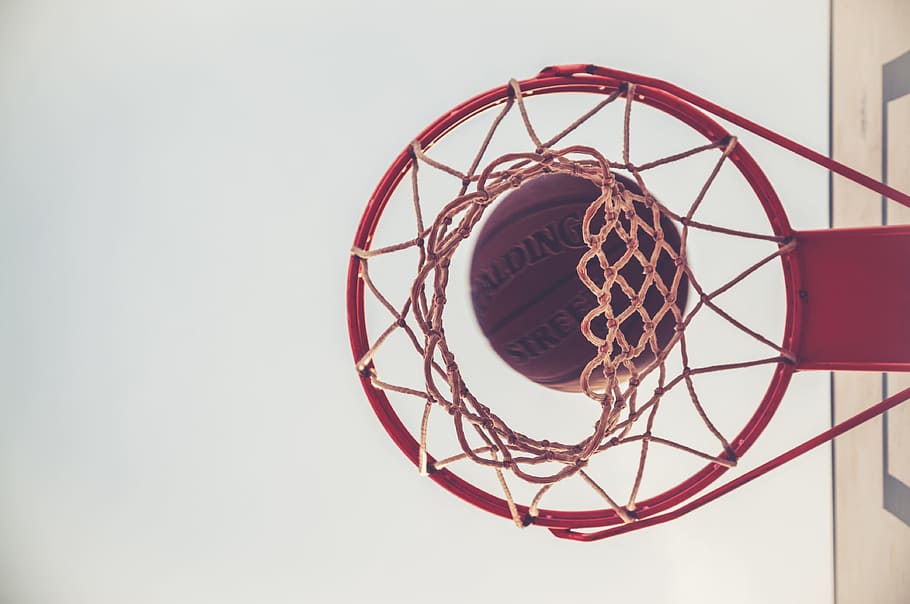 HD brown Spalding basketball on red basketbal ring, equipment | Flare