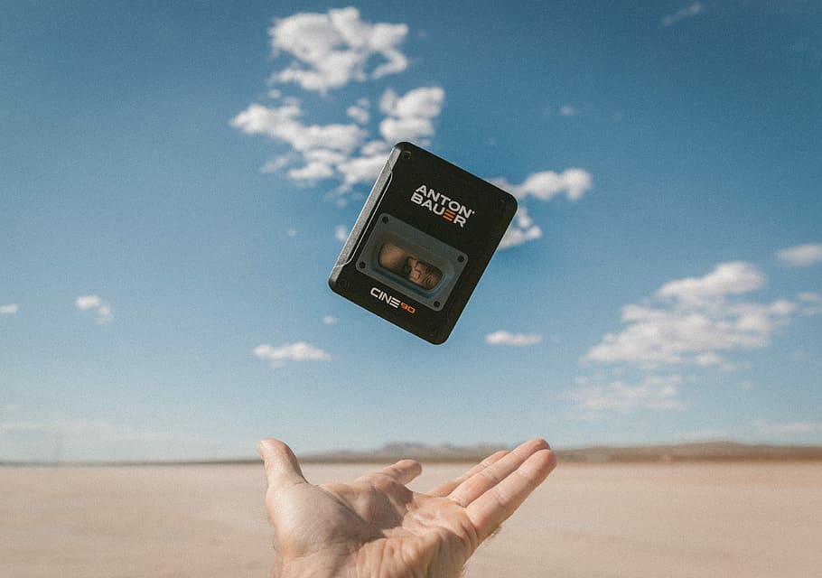 person catching black Anton Bauer device under blue sky during daytime, person catching Anton Bauer digital device HD wallpaper