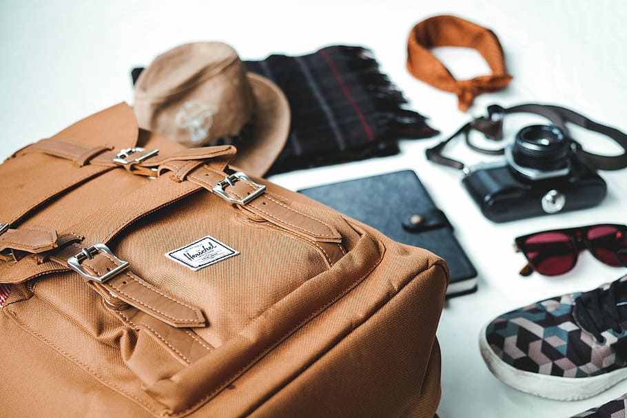 closeup photo of brown leather bag near sunglasses and shoes, brown leather bag on white surface HD wallpaper