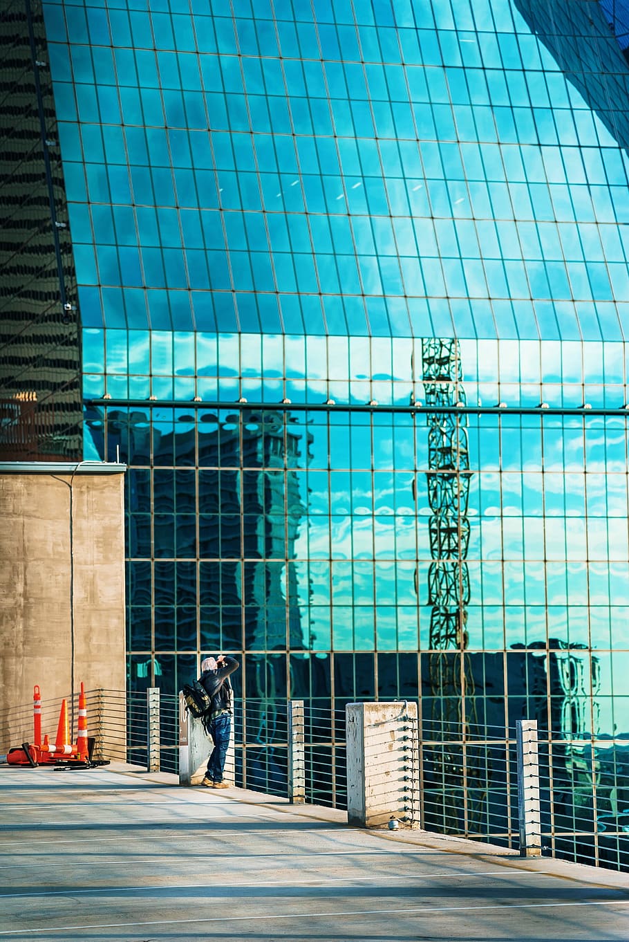 woman standing on fence during daytime, person standing near glass building HD wallpaper