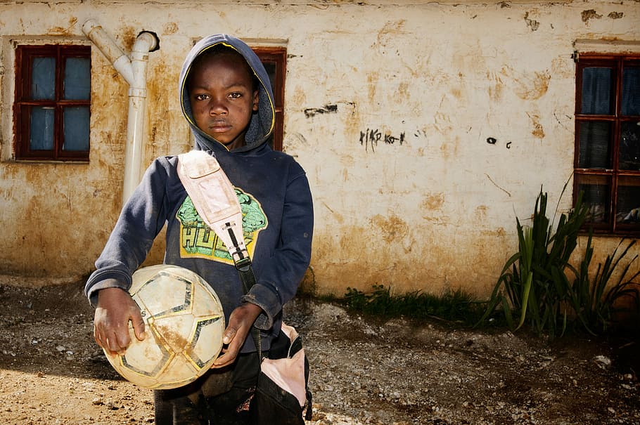 Seguin Plateau, Haiti Soccer Boy, boy in blue hoodie holding soccer ball near building HD wallpaper
