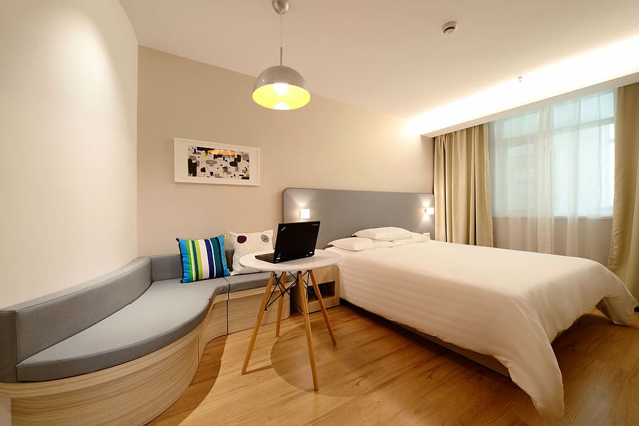 gray bed frame beside white and brown wooden side table, hotel