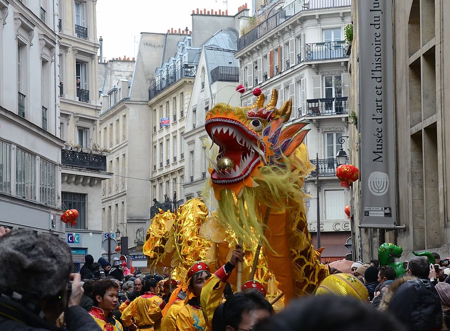 dragon dance at the middle of high-rise buildings, paris, france