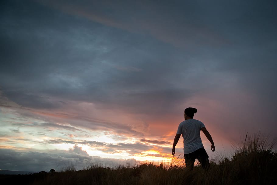man standing on grass under white clouds, man standing over hill taken at sunset, HD wallpaper