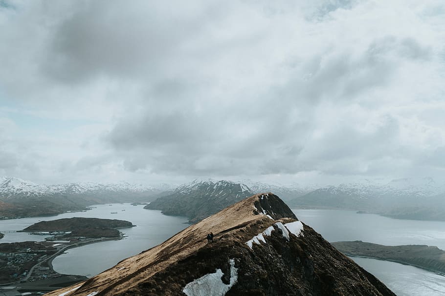 mountain under cloudy sky during daytime, aerial photography of mountain covered with snow during daytime HD wallpaper