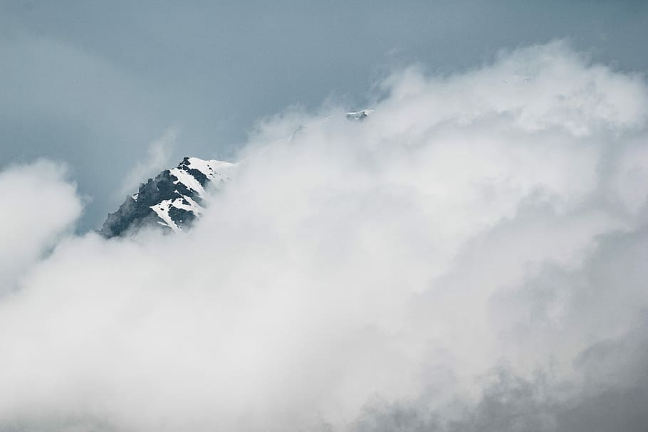 landscape photography of snowy mountain covered white clouds, white clouds covering mountain during daytime HD wallpaper