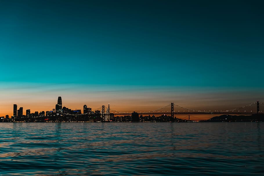 suspension bridge photo during dawn, blue sea and bridge at night HD wallpaper