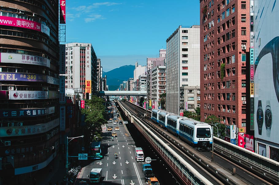 white and blue train near high-rise buildings during daytime, white and blue train on railways near brown and gray concrete buildings HD wallpaper