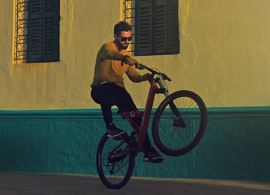 man riding bicycle doing tricks near building photography, man riding on bicycle, HD wallpaper