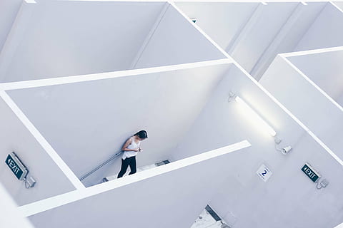 woman standing beside white painted wall while reading notes HD wallpaper