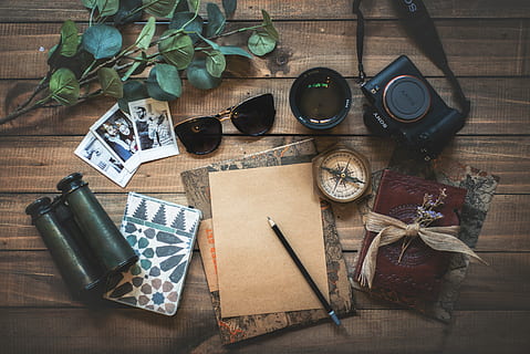 photo of assorted items on wooden table, sunglasses, camera, binocular with pen and cards on brown wooden surface HD wallpaper