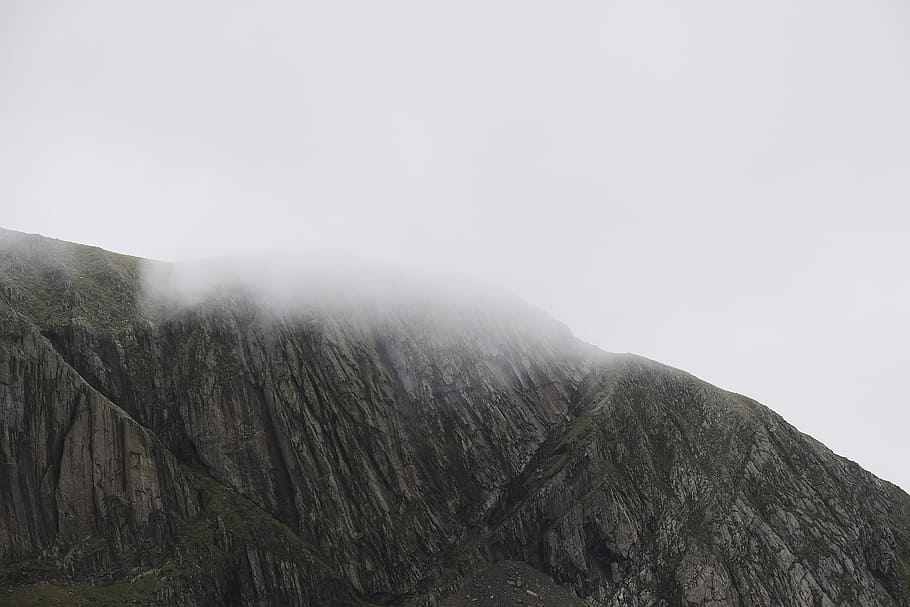 Snowdon in the clouds, rock mountain covered with white fog, hill