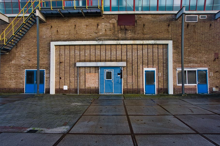 brown concrete structure with blue doors, closed blue doors on building HD wallpaper