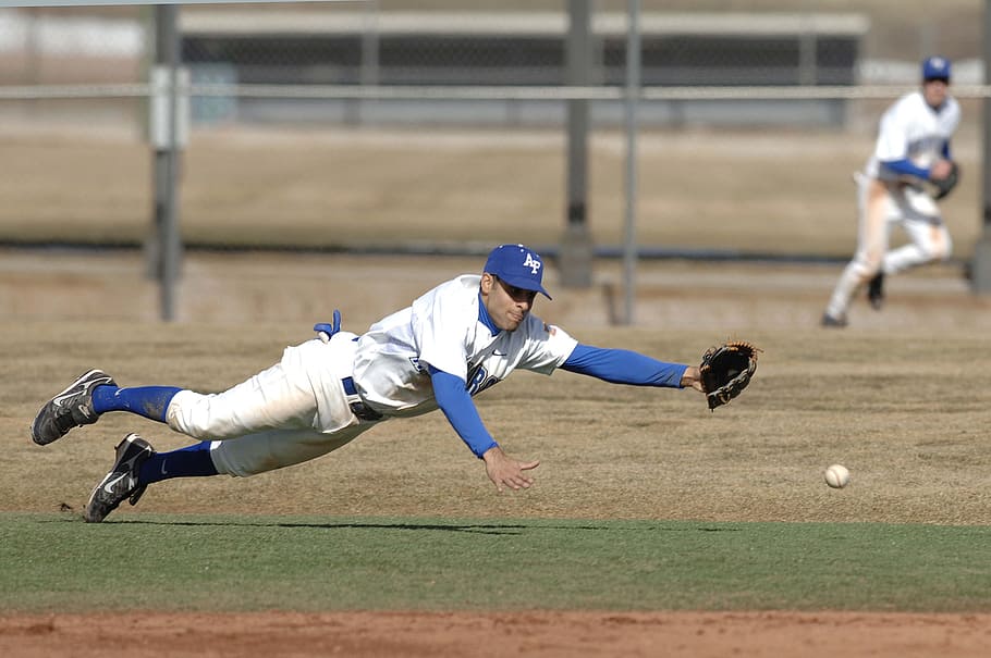 Download A Baseball Player Is Catching A Ball Wallpaper