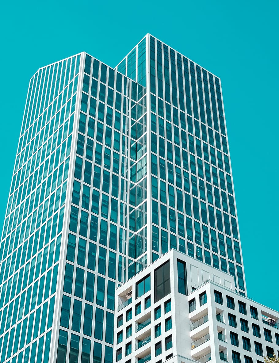 low-angle photography of white framed curtain wall building under blue sky during daytime HD wallpaper