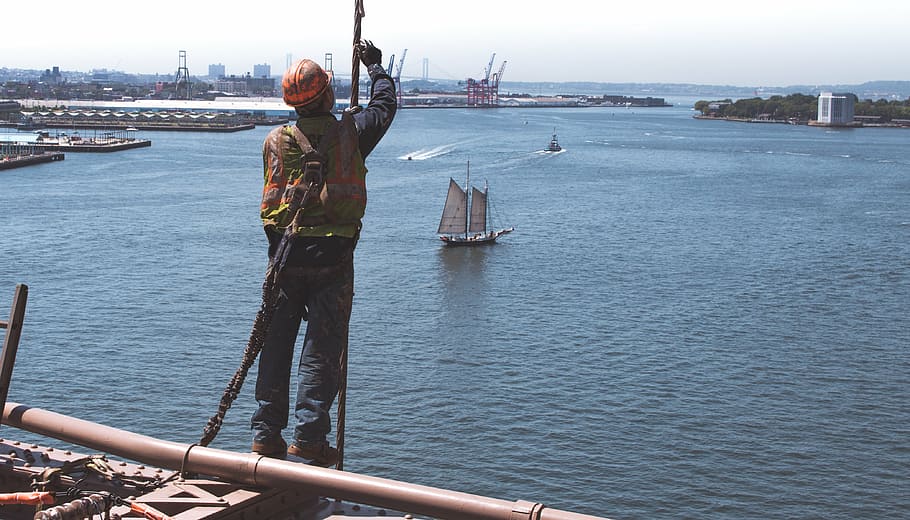 man wearing hard hat on building near body of water, photo HD wallpaper