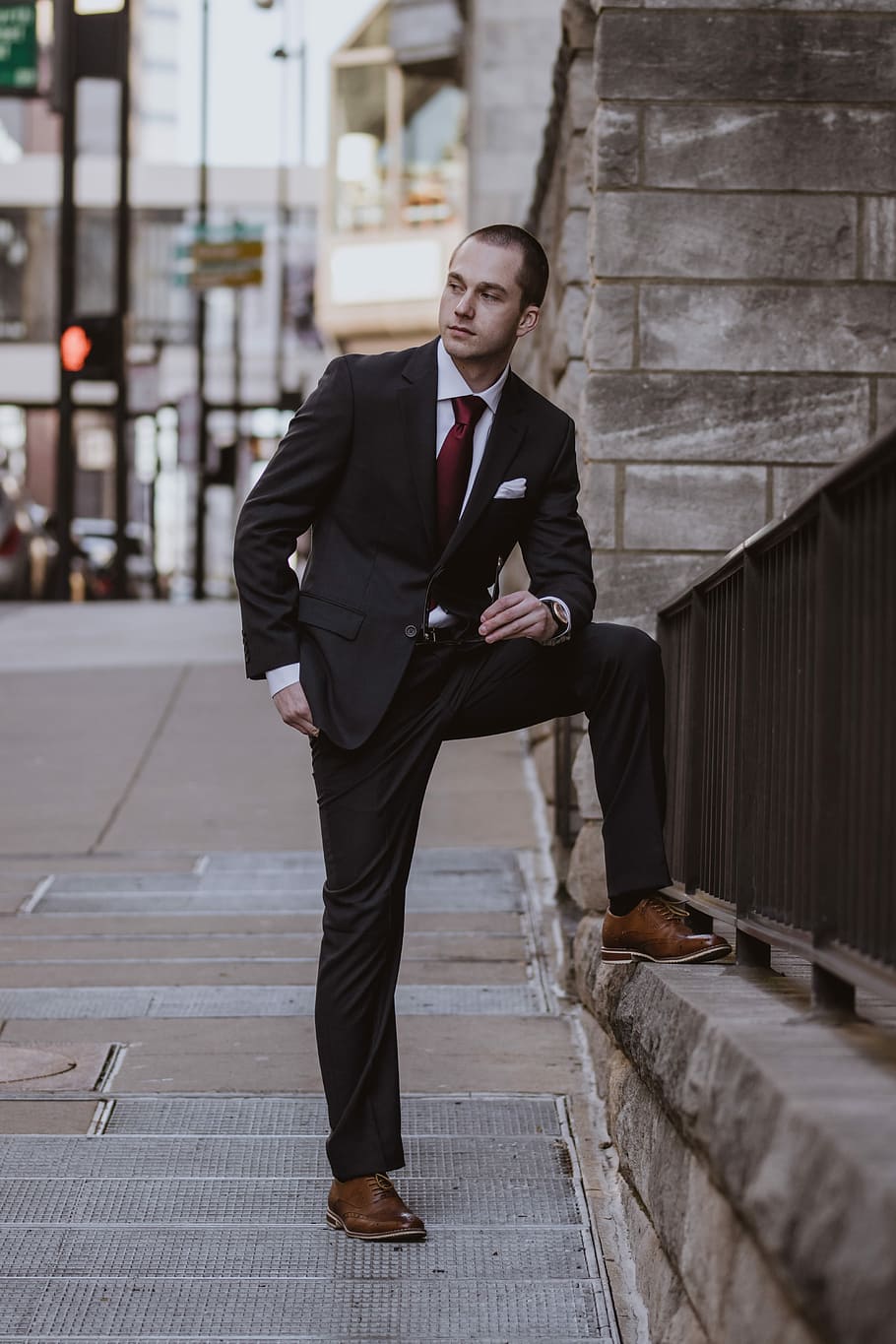 man in black formal suit standing beside concrete building, man wearing black suit standing near railings HD wallpaper