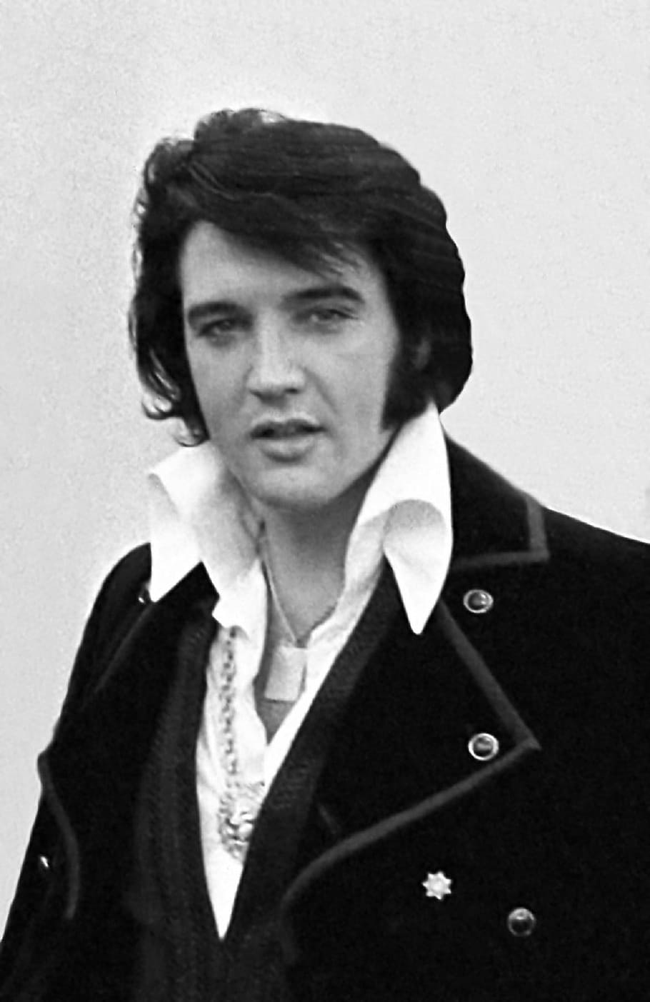 grayscale photo of Elvis Presley in black suit jacket, recording artist
