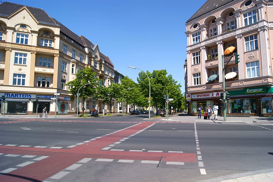people walking and standing beside road and between buildings HD wallpaper