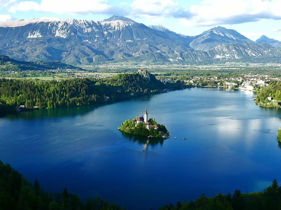 Lake Bled, aerial view of island with castle surrounded by mountains and body of water during daytime HD wallpaper