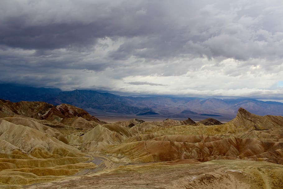 beige mountains under cloudy sky during daytime, aerial photography brown mountains under gray sky atdaytime HD wallpaper