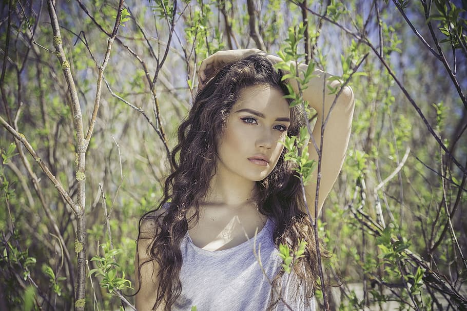selective focus photography of a woman in gray heather tank top surrounded by brown twigs HD wallpaper