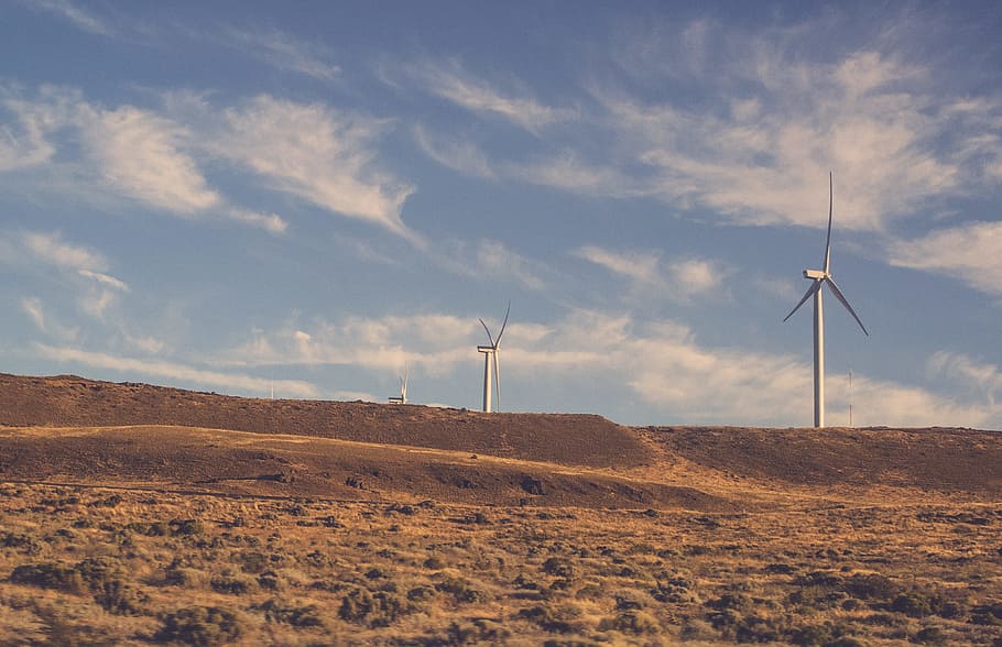 two gray wind turbines under cloudy blue sky during daytime, electric windmill on soil pavement HD wallpaper