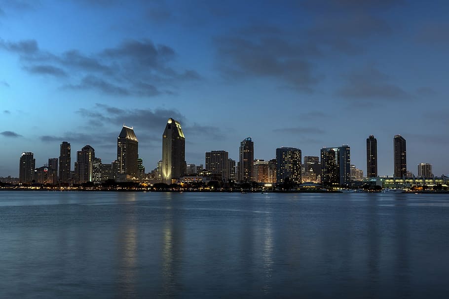 city building in front of body of water, sunset, skyline, dusk HD wallpaper
