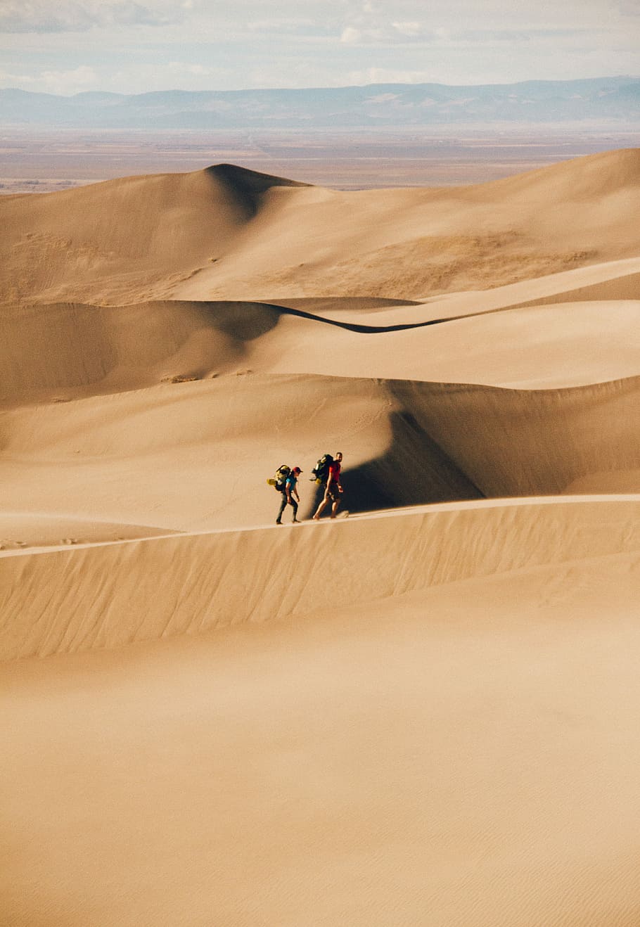 people walking in the desert during daytime, two person walking on desert HD wallpaper