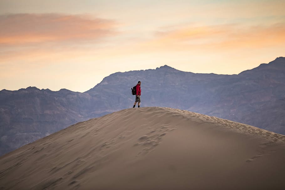man standing on mountain, person standing on desert sand, one person HD wallpaper
