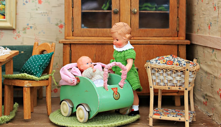girl standing beside baby on stroller figurines, dolls houses