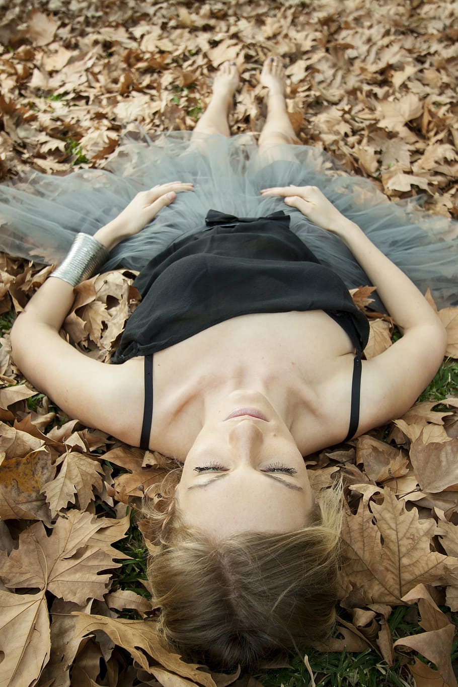 woman wearing black camisole and gray tutu skirt lying on brown leaves HD wallpaper