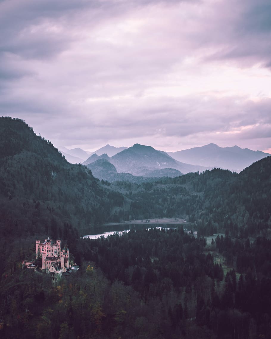 castle on mountain near body of water, green trees, mountain range HD wallpaper