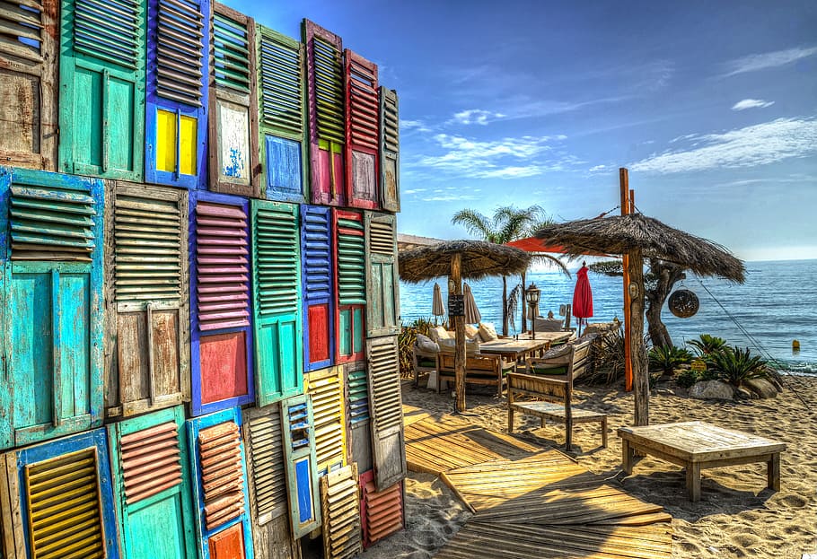 multicolored wooden louvres made into wall near body of water taken during daytime HD wallpaper