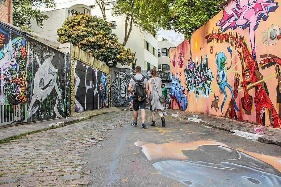 man and woman standing between wall with graffiti artwork, couple walking between murial wall, HD wallpaper