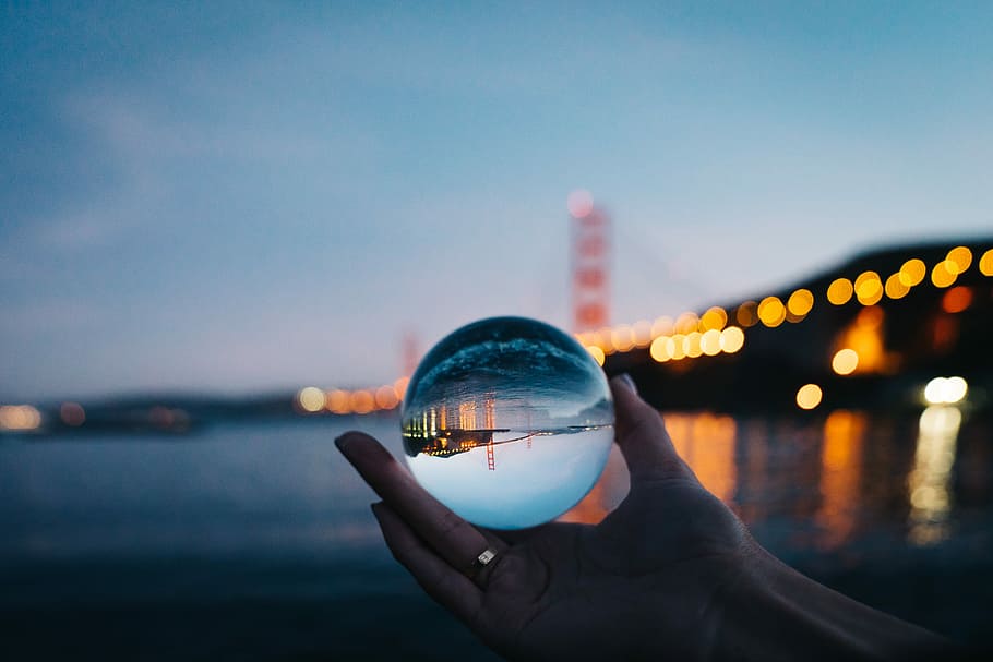 person holding glass ball, person holding glass ball reflecting bridge HD wallpaper