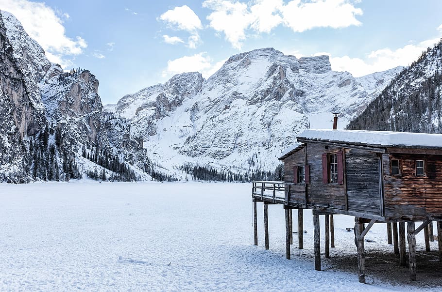 brown wooden house near mountains covered with snow at daytime, shack near mountain filled with snow HD wallpaper