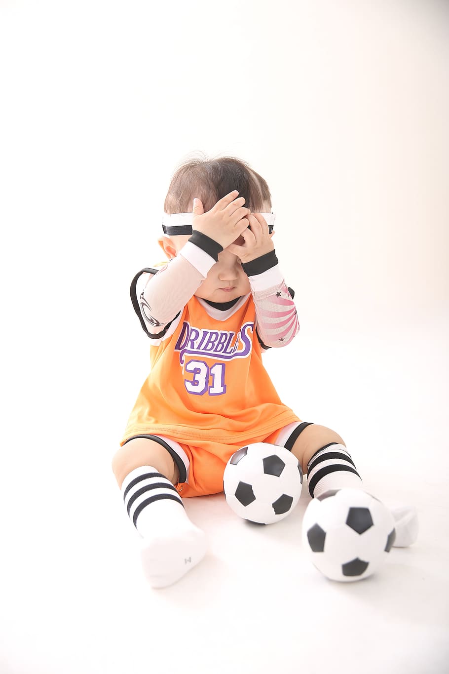 baby wearing soccer jersey holding his headband with soccer balls, HD wallpaper