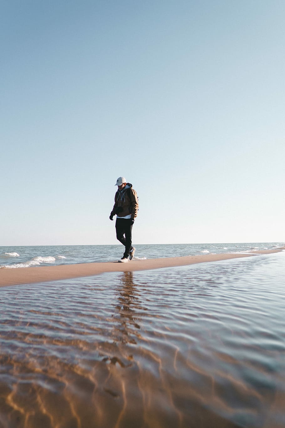 man walks on pathway in middle of body of water during daytime, man walks between sea during daytime HD wallpaper